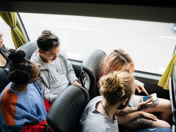 Groupe d'amis voyageant ensemble regardant des photos de leurs téléphones